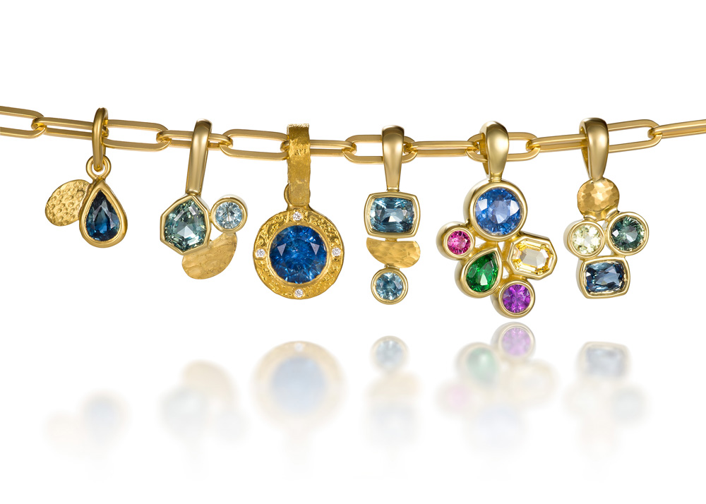 Group of vibrant and colorful gemstone pendants resting on a gold chain