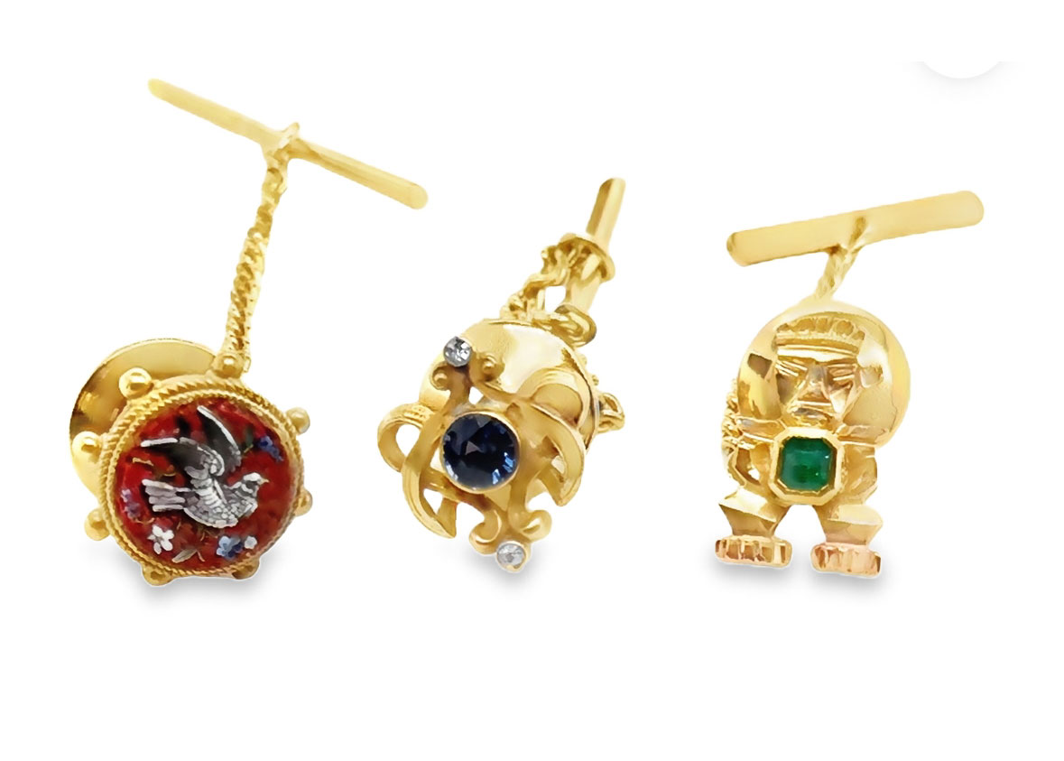 Close up of 3 golden heirloom charms