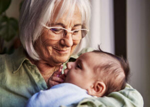 Smiling grandmother holding her baby grandchild.